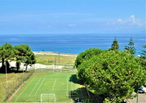 un campo de fútbol con árboles y el océano en el fondo en Casa a Cocca, en Briatico