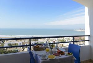 a table with food and a view of the ocean at Anezi Tower Hotel in Agadir