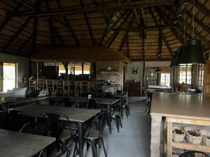 een eetkamer met tafels en stoelen in een gebouw bij Vilagama Game Lodge in Mookgophong