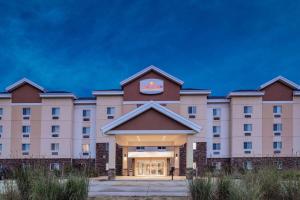 um grande edifício cor-de-rosa com um cartaz. em Hawthorn Suites by Wyndham Dickinson em Dickinson