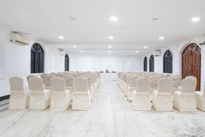 an empty room with white chairs and a table at Shelter Beach Resort in Mahabalipuram