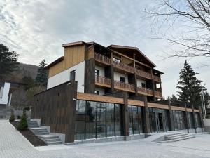 a building with a balcony on top of it at Forest 1961 Boutique Hotel & Restaurant in Vanadzor