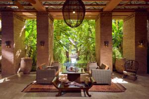 a patio with chairs and a table and a chandelier at Tigmiza Boutique Hotel & Spa in Marrakech