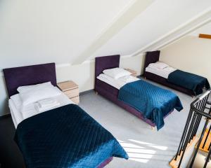 2 Betten in einem Dachzimmer in der Unterkunft Ośrodek Konferencyjno-Wypoczynkowy "Parzenica" w Zakopanem in Zakopane