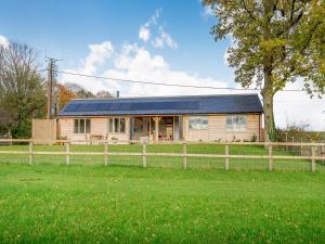 une maison avec des panneaux solaires au-dessus d'un champ dans l'établissement Windover Barn, à Slinfold