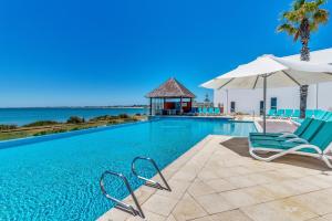 a swimming pool with chairs and a gazebo at Suite 3201 Three Bedroom Luxe Oceanview Apartment in Mandurah