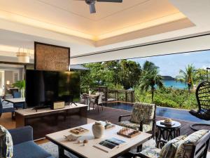 a living room with a view of the ocean at Raffles Seychelles in Baie Sainte Anne