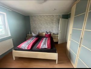 バイアースブロンにあるNatalieのベッドルーム1室(赤い枕のベッド1台付)
