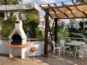 a patio with an outdoor oven and a table and chairs at Gorgeous 2 Bed Private Ground Floor Home In One Of Sides Most Exclusive Communi in Side