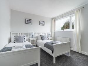 2 camas en una habitación blanca con ventana en Howick House - Large 3 bedroom house, Gosforth en Kenton