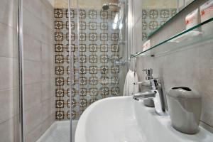 un bagno con un lavandino bianco e una doccia di Vallettastay Old Lodge Apartment 1 a La Valletta