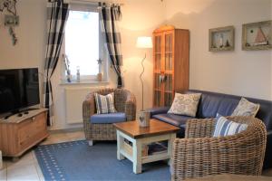 a living room with a couch and two chairs and a tv at Robby1 in Kaltenhof