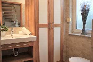 a bathroom with a sink and a toilet and a window at Robby1 in Kaltenhof +9 photos