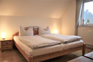 a bedroom with two beds with white sheets and a window at Robby1 in Kaltenhof