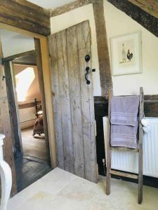 a room with a wooden door and a chair at 14th Century Medieval Longhouse 