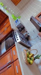 a kitchen with a basket of fruit on a counter at Armelle Sweet Home in Douala