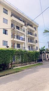 un gran edificio blanco con una valla delante en Armelle Sweet Home, en Douala