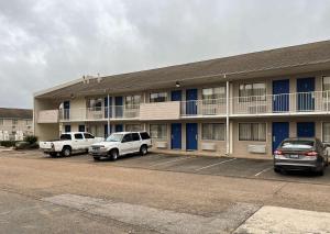 a building with two cars parked in a parking lot at Motel 6 Millington TN in Millington