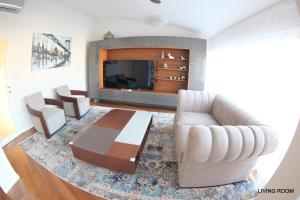 ein Wohnzimmer mit einem Sofa und einem TV in der Unterkunft Luxury Marina View Apartment Izola in Izola