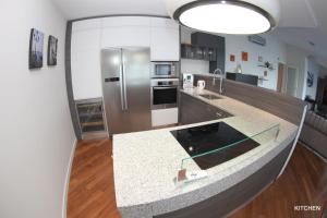 una cocina con encimera y refrigerador en Luxury Marina View Apartment Izola, en Izola