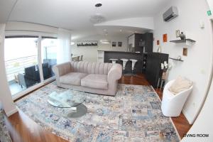 ein Wohnzimmer mit einem Sofa und einem Tisch in der Unterkunft Luxury Marina View Apartment Izola in Izola