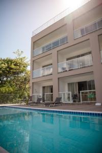 a building with a swimming pool in front of a building at Paraíso da Enseada de Brito in Palhoça +87 photos