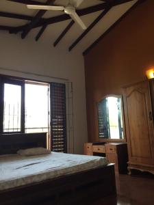 a bedroom with a bed and two windows at Serene Holiday Home in Pannipitiya