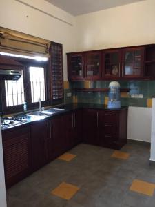 a kitchen with wooden cabinets and a sink and a window at Serene Holiday Home in Pannipitiya