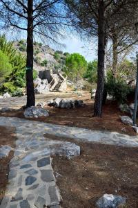 un parque con árboles y un camino de piedra en Camping TajoRodillo, en Grazalema