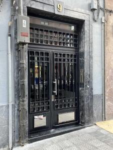 uma porta preta para um edifício com um sinal sobre ele em Recién reformado junto a metro San Mamés em Bilbao