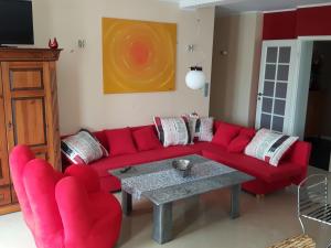 um sofá vermelho e duas cadeiras numa sala de estar em Luxury-Apartment Peter em Bonn
