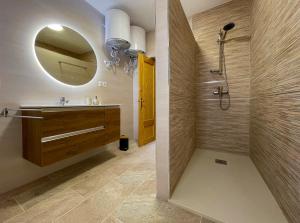 uma casa de banho com um lavatório e um chuveiro com um espelho. em Las Tres Hermanas em Salobreña