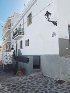 un edificio blanco con una luz en el costado en Las Tres Hermanas en Salobreña