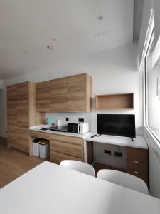 a kitchen with wooden cabinets and a table and chairs at Apartamentos Pillotegi parking gratuito in San Sebastián