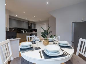 a kitchen and dining room with a white table and chairs at Howick House - Large 3 bedroom house, Gosforth in Kenton