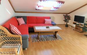 a living room with a red couch and a coffee table at Ferienwohnung Wenzl in Zandt