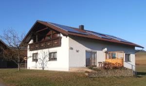 Casa blanca con techo marrón en Ferienwohnung Wenzl, en Zandt