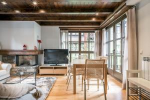 Una sala de estar con una mesa y sillas y un televisor. en Ticolet by Totiaran v2, en Naut Aran (Alto Arán)