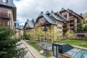 Un edificio de apartamentos con piscina enfrente. en Ticolet by Totiaran v2, en Naut Aran (Alto Arán)