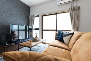 a living room with a couch and a tv at Mita Guest house - Vacation STAY 12100 in Tokyo