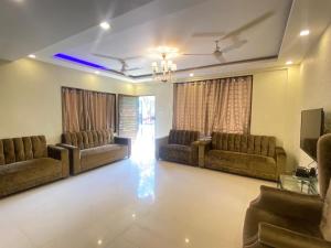 a living room with couches and a chandelier at Mount Bungalows-Mount Paradise-6BHK-PVTPOOL in Lonavala