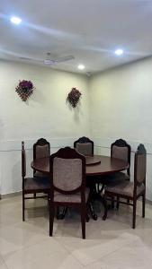a dining room table and chairs with flowers on the wall at Mount Bungalows-Mount Paradise-6BHK-PVTPOOL in Lonavala