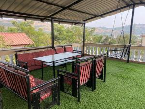 a patio with a table and chairs on a balcony at Mount Bungalows-Mount Paradise-6BHK-PVTPOOL in Lonavala