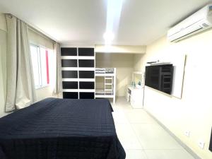 1 dormitorio con 1 cama y TV en Cobertura Luxo com Jacuzzi Orla Praia Grande, en Arraial do Cabo