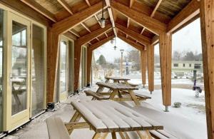 a covered porch with picnic tables in the snow at Panoramatent, in de natuur aan zee in Callantsoog