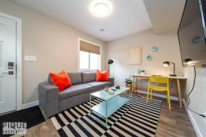 a living room with a couch and a table at NEW, Euro-Style Suite, Whyte Avenue, Netflix, Sleeps 6! in Edmonton