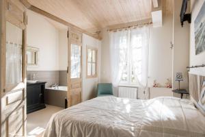1 dormitorio con 1 cama y baño con lavamanos en Violette maison de charme au cœur de St Martin, en Saint-Martin-de-Ré