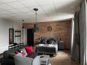 a living room with a bed and a brick wall at Apartamenty Skierniewice Mireckiego in Skierniewice