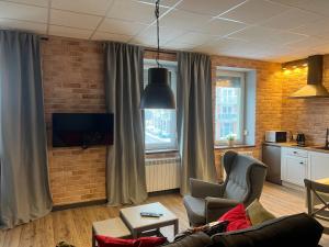 a living room with a couch and a brick wall at Apartamenty Skierniewice Mireckiego in Skierniewice