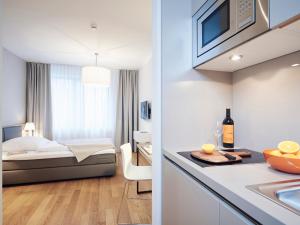a hotel room with a bed and a kitchen at ipartment Frankfurt Europaviertel in Frankfurt/Main